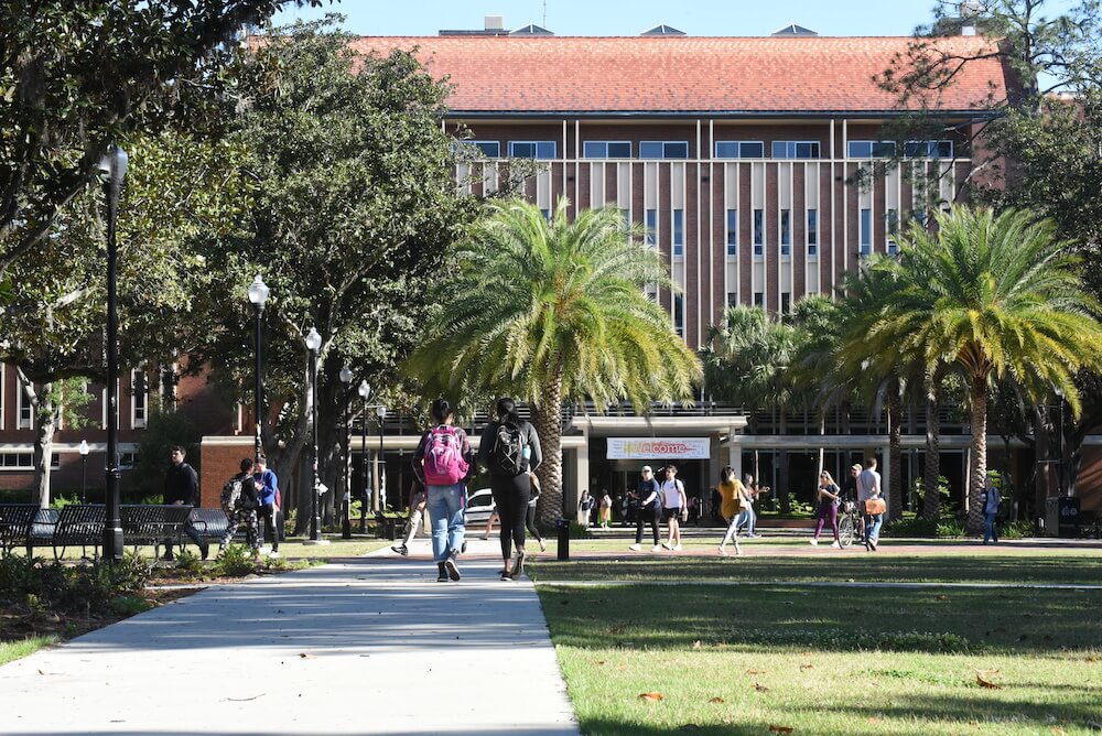 College students walk across the campus of UF between classes