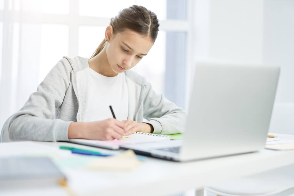 Student preparing to apply to colleges on her laptop