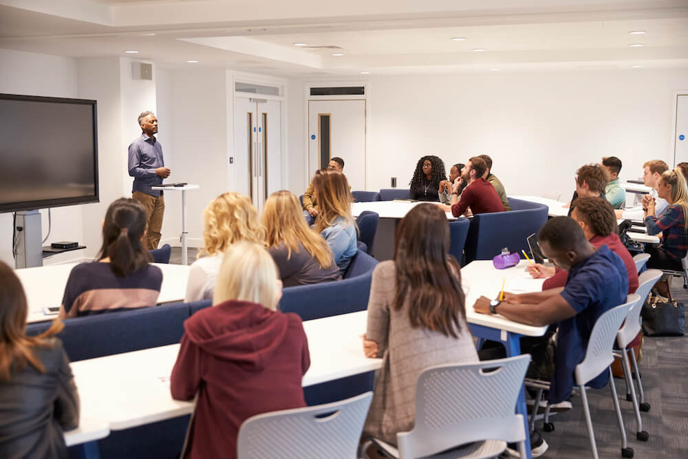 University students study in a business school classroom with male lecturer