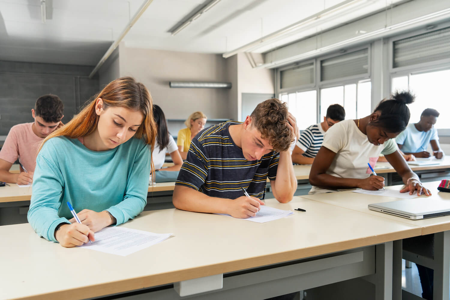Multi ethnic teenager students taking exam at High School