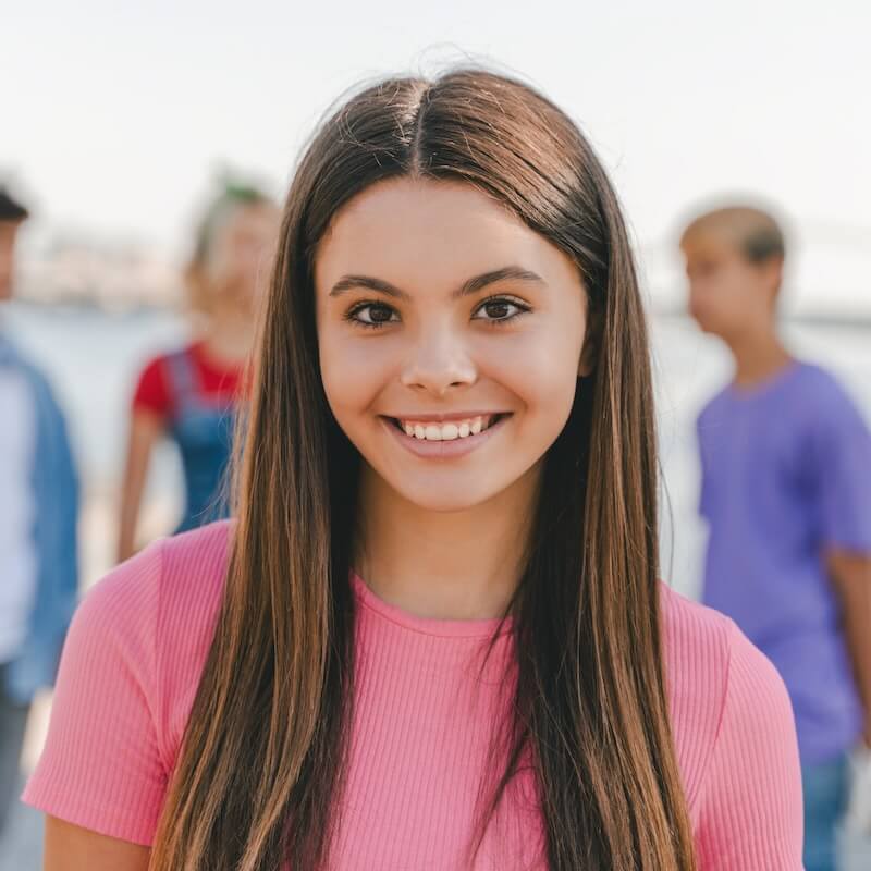 Portrait Of Smiling Teenage Girl Standing On The Street Looking At Camera Student A is creating a balanced college list