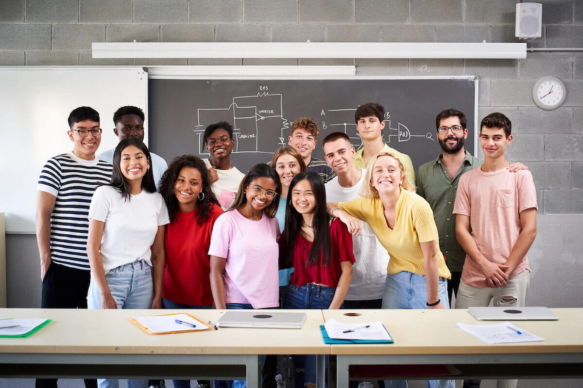 AP, IB, and A-Level students standing as a group in a classroom smiling