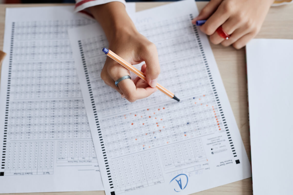 Top view teenage girl completing scantron with an A to earn a 4.0 GPA