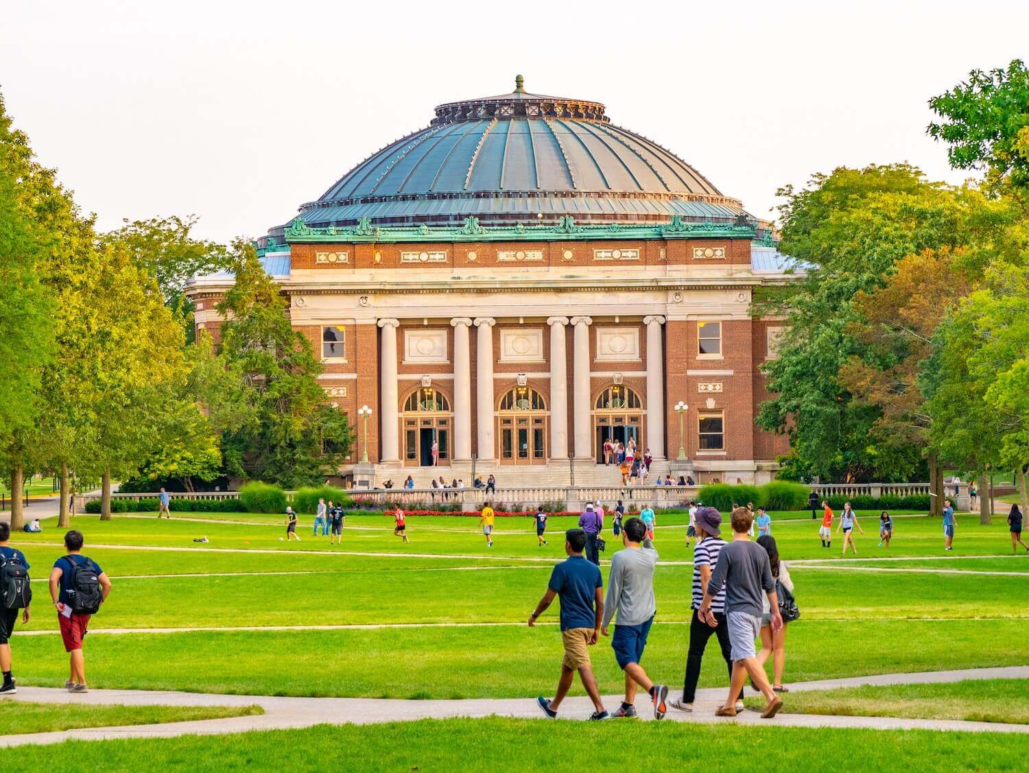 A vibrant U.S. college campus with international and domestic students walking on the green lawn, symbolizing shifting interest in U.S. higher education due to recent student visa policy changes.