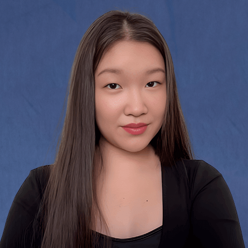 Kailee, Senior Tutor, wearing a black top, smiling softly in front of a light background