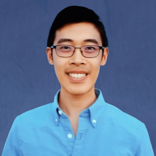 Kyle, Senior Tutor wearing a light blue shirt, smiling with a cityscape and palm trees in the background