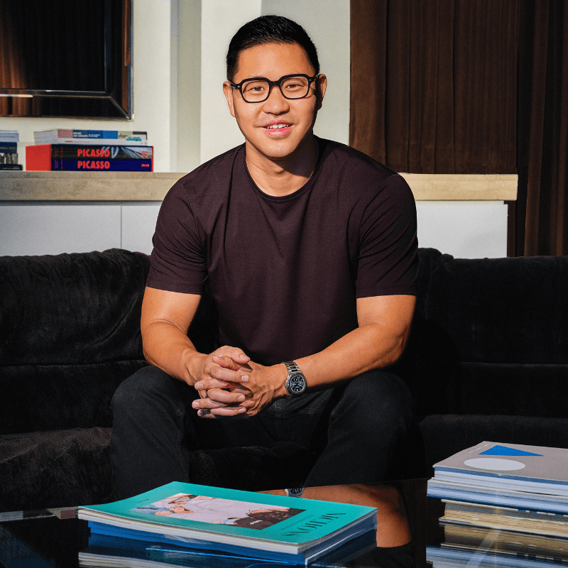 Chris Rim, CEO and Founder, in a navy blue shirt, sitting casually with his hands clasped, in front of a neutral background