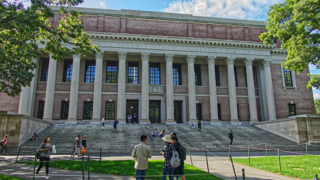 Students walking outside Widener Memorial Library on Harvard University campus on a sunny day