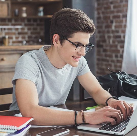 high school student working at their laptop studying
