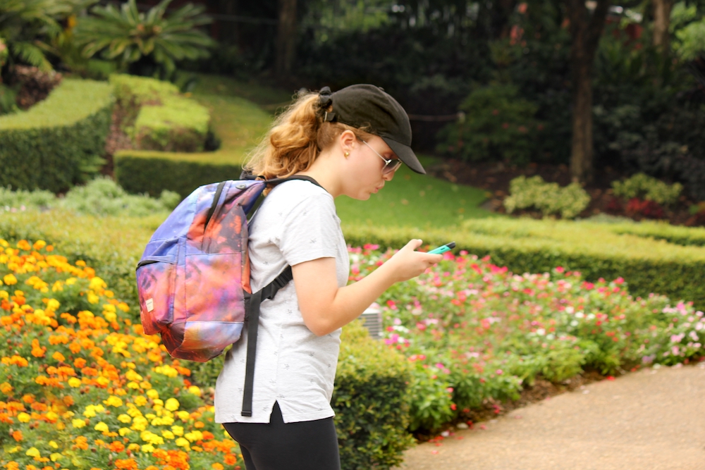 Teenage girl walking and looking at her phone